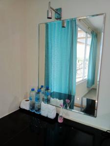 een badkamer met een spiegel en enkele flessen water bij Marina Seaview Krabi in Krabi town