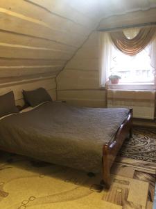 - une chambre avec un lit dans une pièce dotée d'une fenêtre dans l'établissement Біля комори, à Pilipets