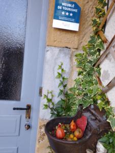 una olla de fruta sentada junto a una puerta en Au charmant chablis, en Champagnole