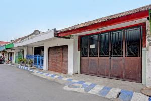 un bâtiment avec deux portes de garage dans une rue dans l'établissement OYO 91865 Sidomulyo Kost Syariah, à Mojokerto