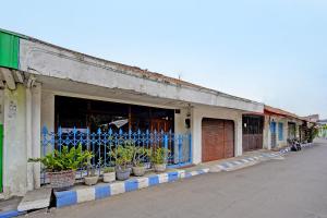 un bâtiment avec des plantes en pot sur le côté d'une rue dans l'établissement OYO 91865 Sidomulyo Kost Syariah, à Mojokerto