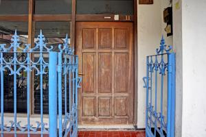 une porte bleue devant une porte en bois dans l'établissement OYO 91865 Sidomulyo Kost Syariah, à Mojokerto