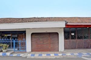 un bâtiment avec deux portes de garage et un portail dans l'établissement OYO 91865 Sidomulyo Kost Syariah, à Mojokerto