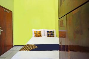 1 dormitorio con 1 cama con 4 almohadas en OYO Life 91869 Insan Mulia Kost Syariah, en Mojokerto