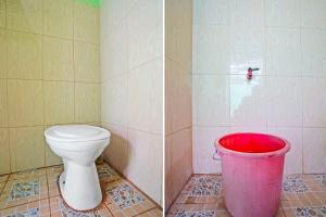 ein Badezimmer mit einem WC und einem roten Eimer in der Unterkunft OYO Life 91869 Insan Mulia Kost Syariah in Mojokerto