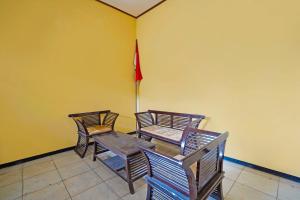 trzy drewniane krzesła i stół w pokoju w obiekcie OYO Life 91869 Insan Mulia Kost Syariah w mieście Mojokerto