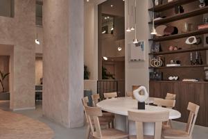 een eetkamer met een witte tafel en stoelen bij The Lekka Hotel & Spa in Athene