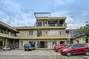 ein großes Gebäude mit Autos auf einem Parkplatz in der Unterkunft OYO Life 91873 Nugraha Kost in Palembang