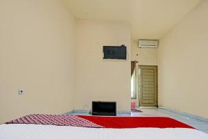 a bedroom with a bed and a tv on a wall at OYO Life 91873 Nugraha Kost in Palembang