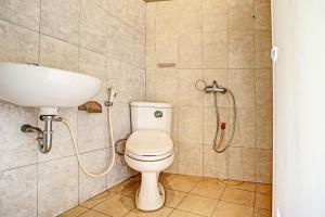 a bathroom with a shower and a toilet and a sink at OYO Life 91873 Nugraha Kost in Palembang