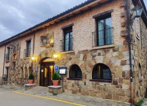 a brick building with windows and a door at Hotel Leonor Mirón in Soria
