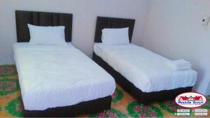 2 Betten nebeneinander in einem Zimmer in der Unterkunft อวบอิ๋มรีสอร์ท #ที่พักภูกระดึง in Ban Nong Tum