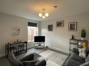 a living room with a couch and a tv at Windmill View Apartments in Lincolnshire