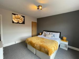 a bedroom with a bed with a yellow blanket at Windmill View Apartments in Lincolnshire