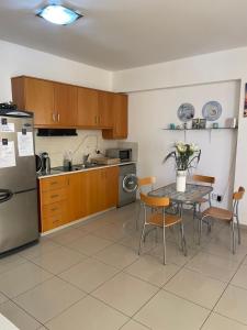 eine Küche mit einem Tisch und einem Kühlschrank in der Unterkunft VIP Resort Apartment on Makenzie Beach in Larnaka