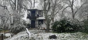 a house with a balcony in the snow at Umzimkulu River Lodge in Underberg