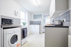 Una cocina blanca con lavadora y secadora. en homely - Great Yarmouth Beach Apartments, en Great Yarmouth