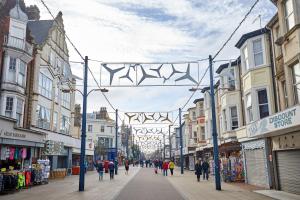 a city street with people walking down the street at homely - Great Yarmouth Beach Apartments in Great Yarmouth