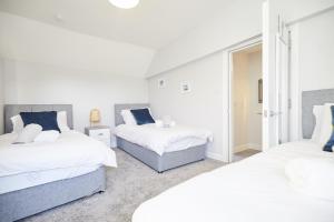 1 Schlafzimmer mit 2 Betten und einem Fenster in der Unterkunft homely - Great Yarmouth Beach Apartments in Great Yarmouth