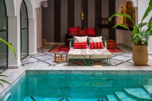 - un salon avec une piscine, 2 chaises et un canapé dans l'établissement Riad SofYan & Spa, à Marrakech