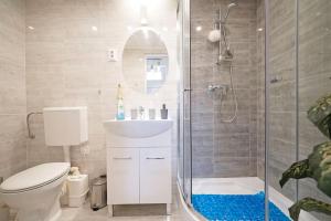 een badkamer met een douche, een toilet en een wastafel bij R69 Apartment in Boedapest