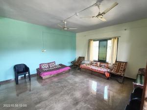 an empty living room with a couch and chairs at Basant - Madhu in Alibaug
