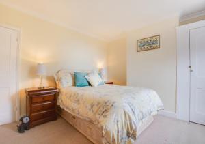 a bedroom with a bed and a night stand with a lamp at Seascape in Walmer