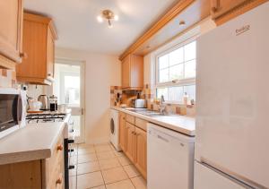 a kitchen with white appliances and a window at Seascape in Walmer