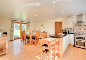 a kitchen with a table and a dining room at Shuttleworth Lodge in Thursford