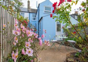 a blue house with flowers in front of it at Seascape in Walmer