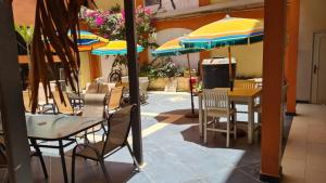 a restaurant with tables and chairs and umbrellas at Hôtel La Palmeraie Saint Louis Sénégal in Saint-Louis +39 photos