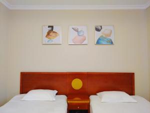 a bedroom with two beds and four pictures on the wall at Milky Way Hotel in Budapest
