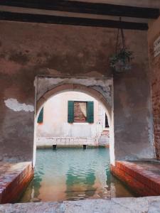 une arche dans un bâtiment avec piscine d'eau dans l'établissement Le Pizzocchere, à Venise