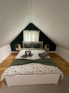 um quarto com uma cama com dois cisnes em Wembley Rooms em Londres