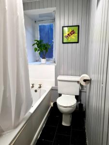 斯特靈的住宿－Nicky-Tams Bar & Apartments，一间带白色卫生间的浴室和窗户。