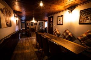 a dining room with a long bar with chairs at Nicky-Tams Bar & Apartments in Stirling