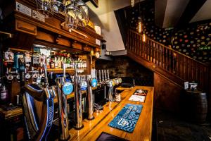 un bar con barra de madera en un pub en Nicky-Tams Bar & Apartments, en Stirling