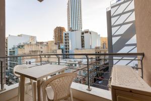a balcony with a table and chairs and a city at Lovely, Spacious High Floor APT in central PV & AC by 360 Estates in Paceville