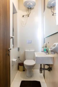 a white bathroom with a toilet and a sink at Lovely, Spacious High Floor APT in central PV & AC by 360 Estates in Paceville