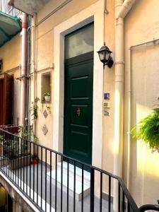 una porta verde sul lato di un edificio di CiuriCiuri Home Appartamento storico nel centro di Catania a Catania