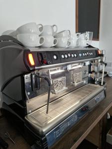 a coffee machine with plates and cups on top of it at Farne Lodge in Beadnell