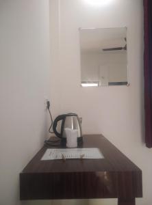 einen Tisch mit einem Wasserkocher und einem Spiegel in der Unterkunft Corbett Bhavesh home Stay in Jhirna