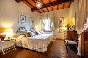 um quarto com uma cama grande e uma janela em Villa S.Andrea em San Casciano in Val di Pesa