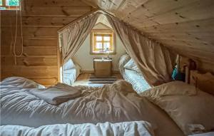 a bedroom with a bed in a log cabin at Amazing Home In seral With Sauna, Wifi And 3 Bedrooms in Åseral