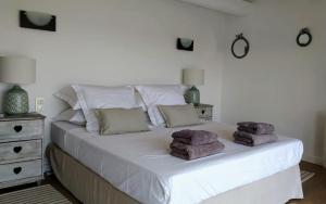 ein weißes Bett mit Handtüchern darauf in einem Schlafzimmer in der Unterkunft Villa Flamants Rose in Marseillan