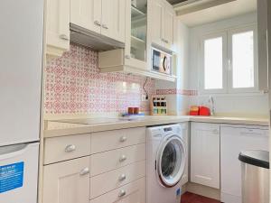 a white kitchen with a washing machine in it at Hispalis Nervión in Seville