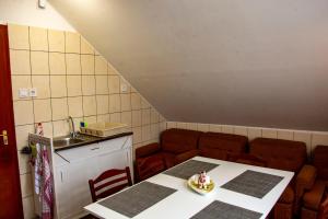 a room with a table and chairs and a kitchen at Luca Apartman in Esztergom