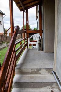 a white chair sitting on a porch with a fence at Luca Apartman in Esztergom