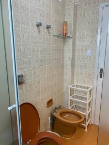 uma casa de banho com um WC e um chuveiro em Apê Clássico e Aconchegante no Guarujá - 350 m da praia no Guarujá