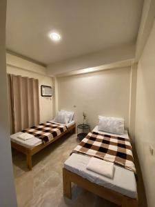two beds sitting in a room with at Antelmi Travelers Inn in Plaridel